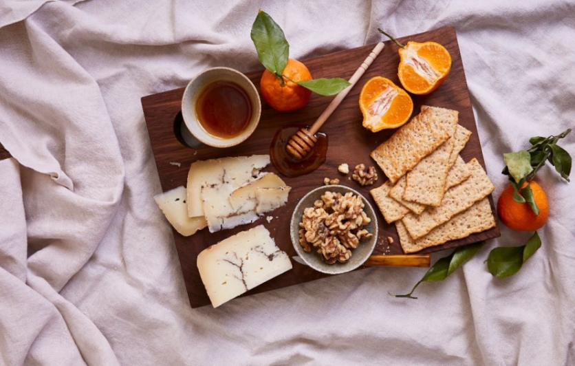 cheese, fruit and crackers on a brown serving platter 
