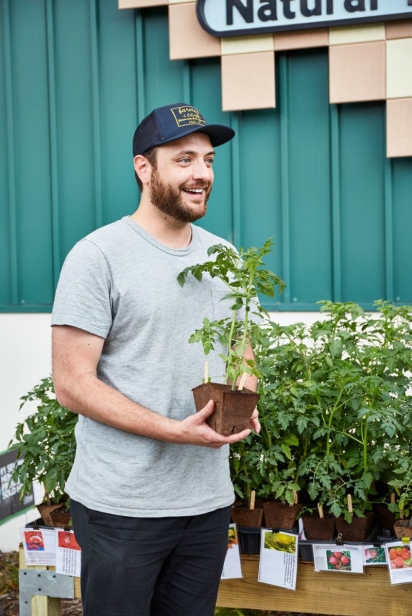 Rosewood Market owner holding potted herbs