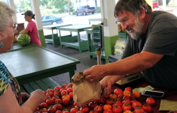 man buying fresh tomatoes.