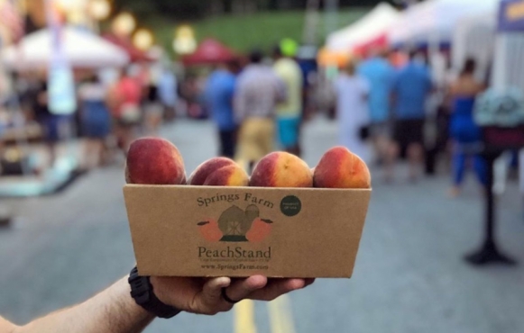 box of fresh peaches at farmers market