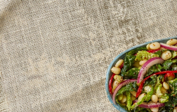 bowl of cabbage and pea slaw on burlap tablecloth