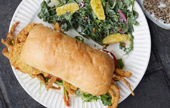 crab sandwich and arugula salad on white plate 