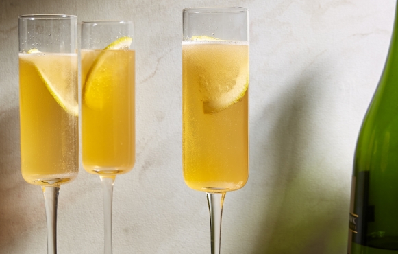 three glasses of yellow bubbly drink