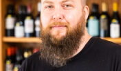 man standing in front of shelf with beer bottles